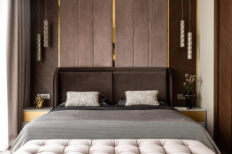 Главная спальня: мягкие стеновые панели у изголовья, кровать и стёганая банкетка